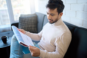 Image showing News, newspaper and man reading article in a home, house or apartment on the weekend sitting on a couch or sofa. Mexican, relax and young person enjoying free time in living room in the morning