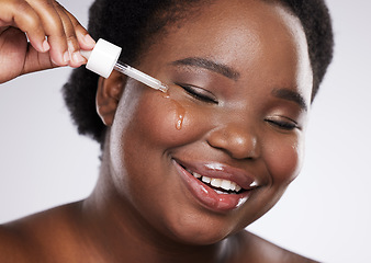 Image showing Black woman, skincare serum and studio for cosmetic beauty, smile and happiness by background. Facial oil product, young african model and natural skin glow with hyaluronic acid detox for wellness