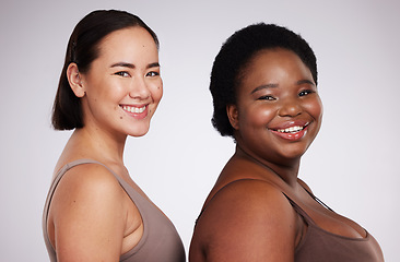 Image showing Portrait, black woman and Asian girl with skincare, friends and smile with confidence, cosmetics and body care on grey studio background. Face, diversity and females with happiness and dermatology