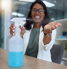 Image showing Hand, covid and sanitizer with a business black woman in her office, sitting at a desk with her spray bottle. Health, safety and cleaning with a female employee using chemical disinfectant at work