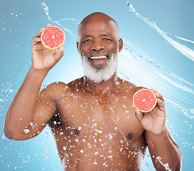 Image showing Black man, portrait smile and fruit for skincare nutrition, vitamin C or hydration against a blue studio background. Happy African American male smiling and holding grapefruit for health and wellness