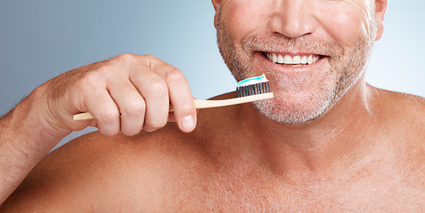 Image showing Smile, mouth or hand brushing teeth with dental toothpaste for healthy oral hygiene grooming in studio. Eco friendly, happy or senior man cleaning gums or lips with a natural bamboo wood toothbrush