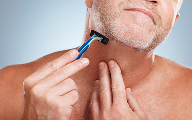 Image showing Grooming, razor and man shaving his beard in a studio for a facial, skincare and epilation routine. Health, wellness and mature male doing face hair removal treatment for self care by gray background