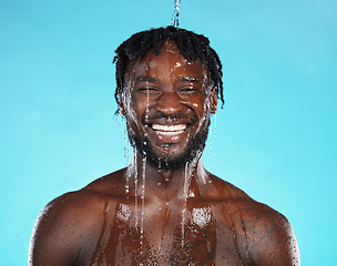 Image showing Shower, portrait and black man isolated on blue background with water drops for face cleaning, body and skincare glow. Strong, beauty and happy model or person in studio headshot washing for hygiene