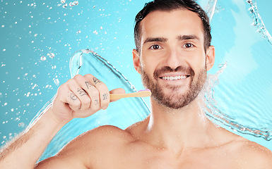 Image showing Eco friendly toothbrush, water and portrait of man on blue background for wellness, hygiene and brushing teeth. Cleaning, dental and face of male with toothpaste for grooming, whitening and health