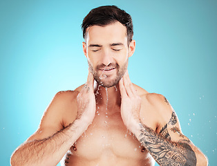 Image showing Skincare, man washing face and water, morning cleaning treatment isolated on blue background. Facial hygiene, splash and male model grooming for health, wellness and clean skin care beauty in studio.