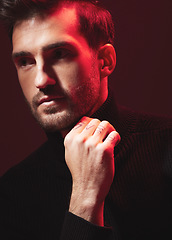 Image showing Thinking, fashion and red with a handsome man model in studio on a dark background for contemporary beauty. Face, idea and art with a handsome male posing indoor to promote trendy clothes or style