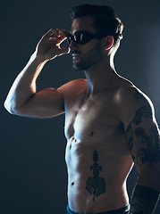 Image showing Sports, fitness and body of swimmer in studio with goggles for wellness, exercise and swimming training. Workout, motivation and man athlete on dark background with muscle, strong body and tattoo