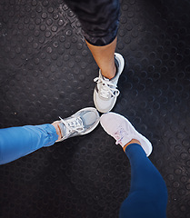 Image showing Women, gym and shoes on floor in circle for teamwork, motivation and support for fitness training. Woman exercise group, sneakers and huddle for team building, solidarity and workout in top view