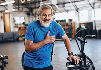 Image showing Fitness, gym and old man with pain in chest, medical emergency during workout at sports studio. Exercise, health and wellness, stress and asian senior person with hand on heart muscle while training.