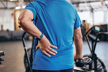 Image showing Sports, gym and old man with hand on back pain, emergency during workout at fitness studio. Health, wellness and inflammation, zoom on senior person hands on muscle cramps while training or exercise.