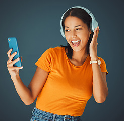 Image showing Selfie, headphones and streaming podcast or music on phone or mobile app isolated against a studio background. Fun, sound and female enjoying and listening to radio or audio smiling and happy