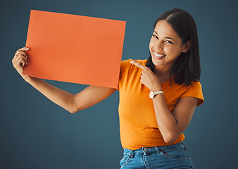 Image showing Woman, poster or banner portrait with mockup space for sale, discount or promotion. Happy model pointing hand advertising product placement, logo or brand billboard on paper sign on blue background