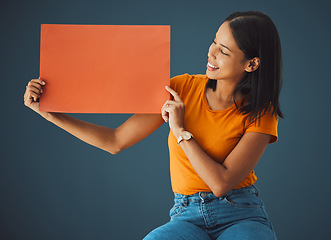 Image showing Woman, poster and mockup banner space for sale, discount or promotion. Happy model with advertising for product placement, logo or branding on billboard orange paper sign in studio background