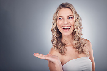 Image showing Beauty, hand space and woman advertising in studio with natural cosmetics and shampoo for hair shine. Aesthetic model on grey background for hairdresser, skincare or salon product placement mockup