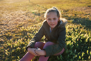 Image showing Nature, portrait and girl on the grass in a park after playing alone on vacation or weekend trip. Natural, beautiful and child having fun and enjoying in outdoor field on holiday in Canada in summer.