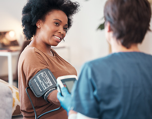 Image showing Black woman, healthcare and blood pressure checkup with caregiver monitoring or checking pulse at home. Happy African American female patient or visit from medical nurse for health and wellness