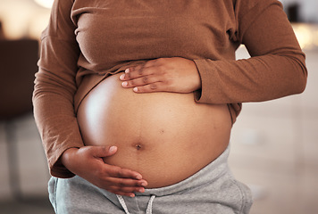 Image showing Hands, stomach and pregnant black woman in home for maternity leave, health and wellness. Pregnancy, prenatal motherhood and female, mama or future mother touching belly with hope for newborn baby.