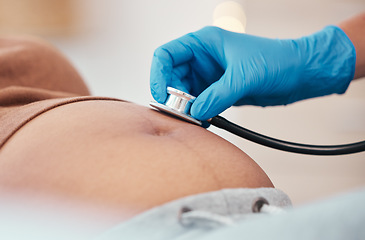 Image showing Hand, stethoscope and the belly of a woman pregnant in a hospital for prenatal exam or checkup in the hospital. Healthcare, medical and pregancy with a doctor listening to the baby of a mother to be