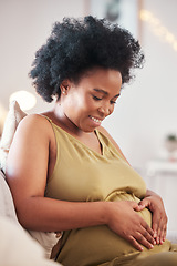 Image showing Pregnant, heart hands and black woman stomach with hand sign feeling mother love. Mom care, sofa and living room lounge with person holding abdomen happy about pregnancy and baby on a house couch