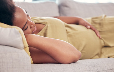 Image showing Pregnant, maternity and sleeping woman resting holding her tummy or stomach and relax expecting a baby. Home, pregnancy and lying on a couch or sofa in a house or apartment on a break in a lounge