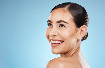 Image showing Skincare, beauty and happy woman in a studio for a natural, cosmetic and face skin treatment. Cosmetics, happiness and female model from brazil with a facial routine isolated by a blue background.