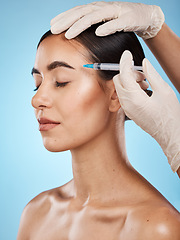 Image showing Skincare, botox and woman in a studio with a beautician for face filler, cosmetic and plastic surgery treatment. Beauty, cosmetology and female model getting a facial injection by a blue background.