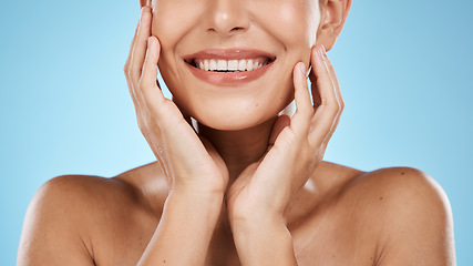 Image showing Skincare, facial and smile of woman on blue background for luxury, wellness and cosmetics in studio. Spa aesthetic, dermatology and mouth of girl with hands for beauty, treatment and healthy skin