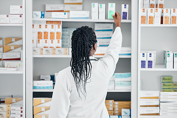 Image showing Choice, back and pharmacist at a shelf for medicine, inventory and check on pills in a clinic. Medical, healthcare and black woman working with medication at a phamacy for service, health and work