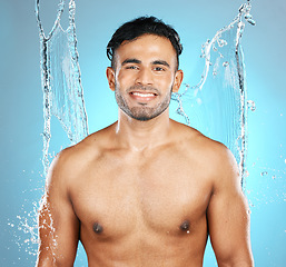 Image showing Water, splash and portrait of man for beauty, skin and skincare cleaning his body, muscle and topless. Mexican, male model with moisture, cleanse and hydration isolated in studio blue background