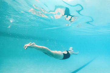 Image showing Swimming, fitness and sports with a woman underwater in a pool for cardio or endurance exercise. Water, swimwear and health with a female swimmer during a workout or competitive watersports game