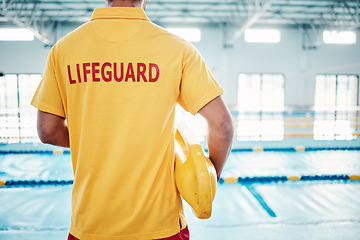 Image showing Security, safety or lifeguard by a swimming pool to help rescue the public from danger or drowning in water. Back view, trust or man standing with a lifebuoy ready with reliable assistance or support