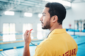 Image showing Lifeguard, whistle and swimming pool safety by man watching at indoor facility for training, swim and practice. Pool, attendant and guy water sports worker monitoring exercise, danger and swimmer