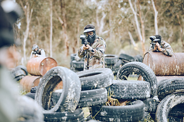 Image showing Paintball, war or gun men in a shooting game playing or training with action on a fun battlefield. Mission focused, military or army team with weapons gear for survival in an outdoor competition