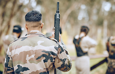 Image showing Paintball, soldier or man with a gun in a shooting game playing on a fun battlefield in nature or forest. Back view, military or warrior with weapons gear for survival in an outdoor competition