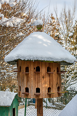 Image showing Wooden Dovecote with a roof cowered by snow