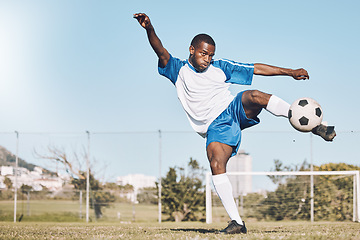 Image showing Sports, soccer and black man kick ball playing game, training and exercise on outdoor field. Fitness, workout and male football player in action, running and score goals, winning and competition