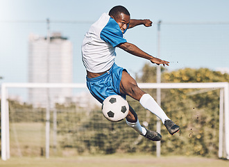 Image showing Soccer, action and man jump with ball playing game, training and exercise on outdoor field. Fitness, workout and male football player kicking, running and score goals, winning and sports competition