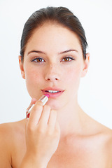 Image showing Woman, face and portrait with lipstick for makeup, cosmetics or skincare isolated against a white studio background. Beautiful happy female applying cosmetic product on lips for beauty in self love