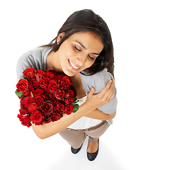 Image showing Above, hug and woman with rose in studio for love, romance and valentines day against a white background space. Happy, smile and bouquet for indian girl embrace floral, gesture and romantic isolated