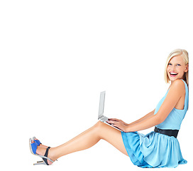 Image showing Portrait, laptop and woman on studio floor, happy and excited on white background space. Face, relax and online, internet or search by casual, smile and cheerful model typing, sitting and isolated