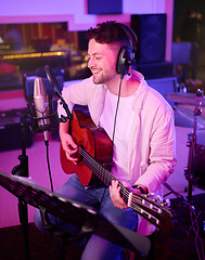 Image showing Singer, headphones or guitar in neon studio, recording production or performance on theater microphone. Happy guitarist, musician or singing man playing on strings instrument in night light practice