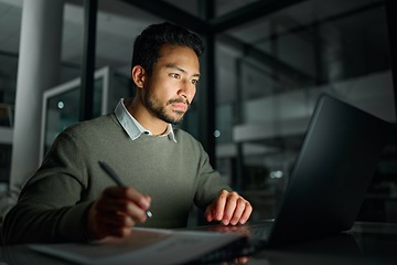 Image showing Business man, laptop and writing notes in office while working on project deadline at night. Overtime, planning or male employee write information on paper for research on computer in dark workplace.