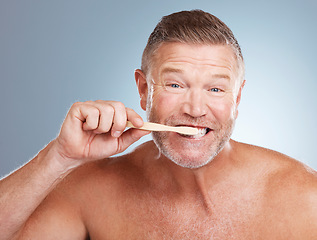 Image showing Portrait, mouth or old man brushing teeth with dental toothpaste for healthy oral hygiene grooming in studio. Eco friendly, funny or senior person cleaning with a natural bamboo wood toothbrush