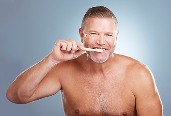 Image showing Smile, portrait or senior man brushing teeth with dental toothpaste for healthy oral hygiene grooming in studio. Eco friendly, happy or mature guy cleaning mouth with a natural bamboo wood toothbrush