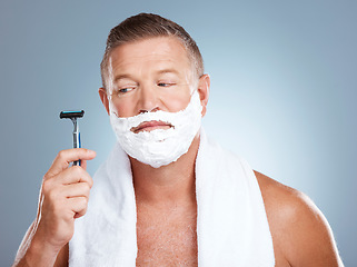 Image showing Skincare, razor and old man shaving in studio with foam, beauty or grooming on grey background. Face, doubt and mature male model relax for luxury, hair removal and facial, skin and product isolated