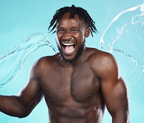 Image showing Water splash, black man and body with shower, happiness and surprise with skincare isolated on blue background..Excited, clean skin and natural cosmetics with grooming, hygiene and beauty in studio