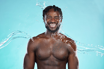 Image showing Water splash, studio and black man isolated on blue background with face cleaning, body and skincare beauty. Strong, muscle and happy model or person in shower aesthetic, wash and dermatology hygiene