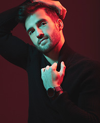 Image showing Man, fashion portrait and studio with red light for clothes, beauty and luxury style on dark background. Face of aesthetic model person with turtle neck, art and cosmetics for inspiration for men