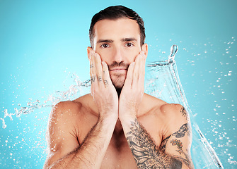 Image showing Water splash, facial and portrait of man with skincare on face and morning detox routine isolated on blue background. Hygiene, male model hands and grooming for health, wellness and beauty in studio.